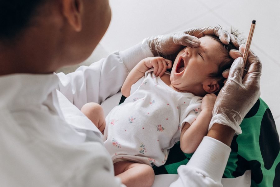Doctor examining a baby at the Well Baby Clinic
