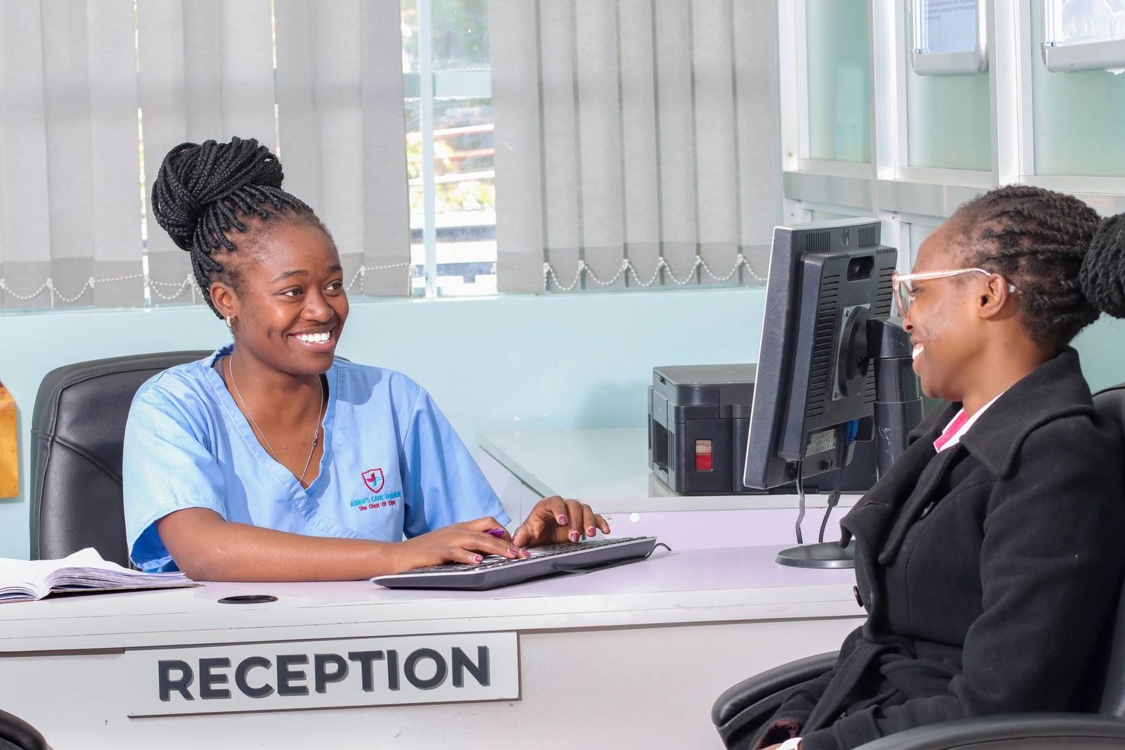 Receptionist welcoming a patient at Asher's Care Hospital front desk